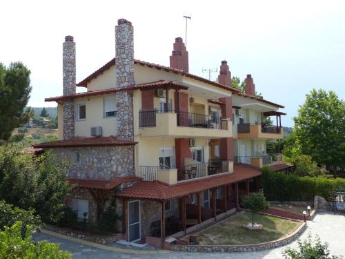 an image of a building with two chimneys at Makis Nest Family Apart-hotel Vourvourou in Vourvourou