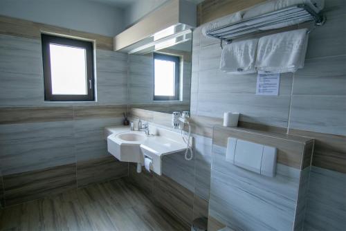 a bathroom with a sink and a mirror at La Conacul Vesel Săpânța in Săpînţa