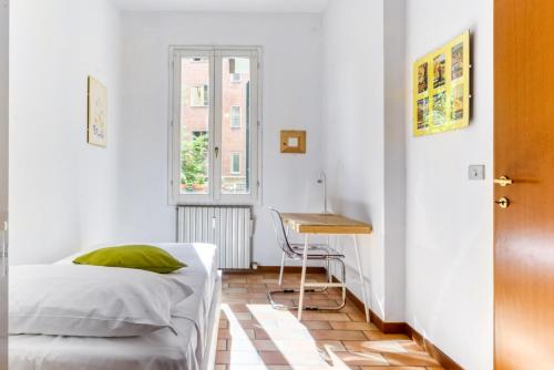 a bedroom with a bed and a table and a desk at Castiglione Family Apartment by Wonderful Italy in Bologna