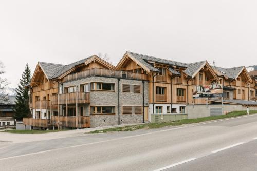 a large wooden house on the side of a road at Chalet Village by Apart4you in Ramsau am Dachstein