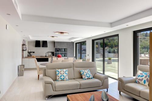 a living room with two couches and a kitchen at Luxury Zen in Châteauneuf