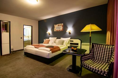 a bedroom with a bed and a chair at La Conacul Vesel Săpânța in Săpînţa