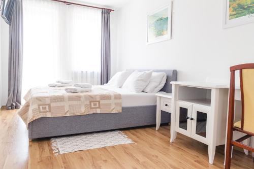 een kleine slaapkamer met een bed en een tafel bij AL-DOM apartamenty Apartament Olymp 302 in Kołobrzeg