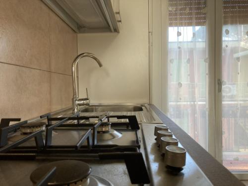 eine Küche mit einer Spüle, einem Herd und einem Fenster in der Unterkunft Milady in Rosolina Mare
