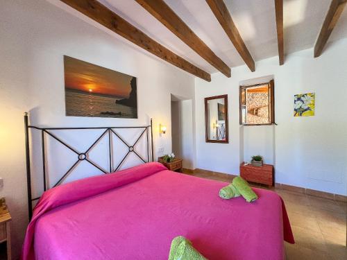 een slaapkamer met een groot roze bed in een kamer bij Finca Son Rengo in Campos