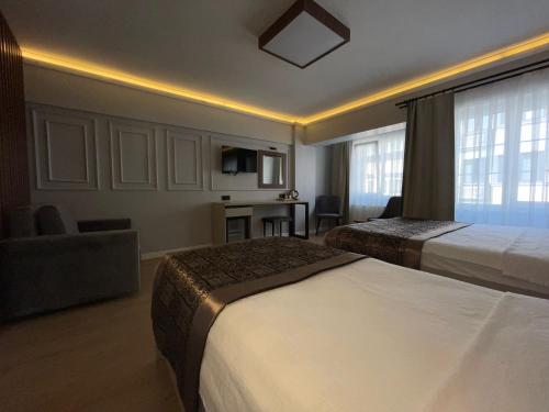 a hotel room with two beds and a couch at AZRA SULTAN HOTEL&SPA in Istanbul