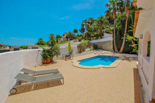 a patio with a swimming pool and lounge chairs at Colina - holiday home with private swimming pool in Moraira in Moraira
