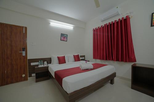 a bedroom with a bed with a red curtain at SM Royal Suites - Hotel near Kempegowda international Airport Bangalore in Devanahalli-Bangalore