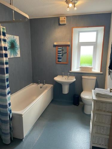 AIRDSIDE COTTAGE في قلعة دوغلاس: حمام مع حوض استحمام ومرحاض ومغسلة