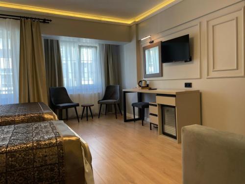 Habitación de hotel con cama, escritorio y TV. en Azra Sultan Hotel & Spa en Estambul