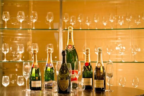 a group of bottles of wine sitting on a bar with glasses at The Lalit Traveller- Airport hotel in Jaipur
