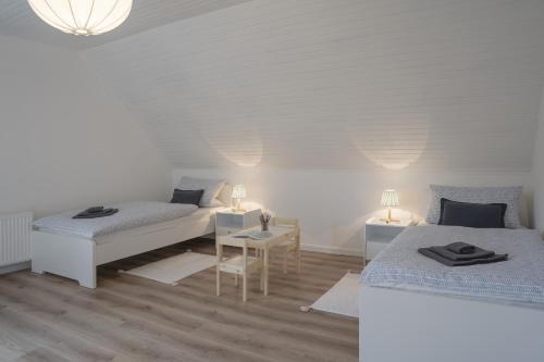 Habitación con 2 camas y mesa con lámparas. en Ferienwohnung meer.pause im Herzen von Grömitz, en Grömitz