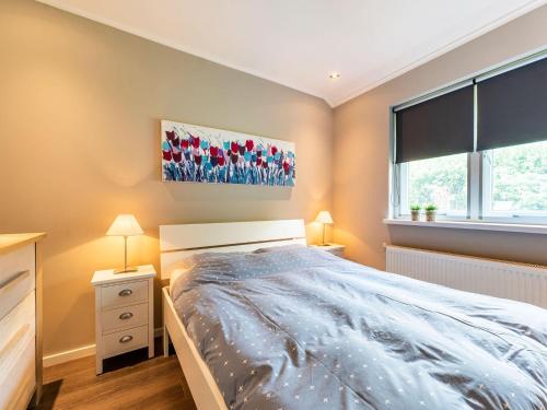 a bedroom with a bed and two lamps and a window at Holiday Home in Garderen with Garden in Garderen