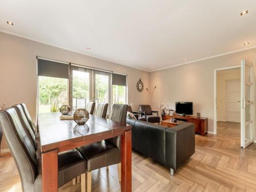 a dining room and living room with a table and chairs at Holiday Home in Garderen with Garden in Garderen