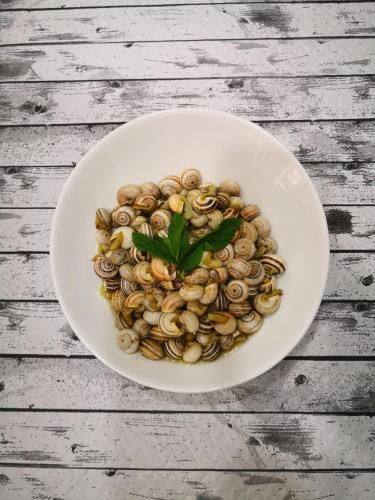 a bowl of pasta with a green leaf on a table at Hotel Aro'S in Casas Ibáñez
