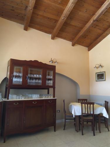 ein Esszimmer mit einem Tisch und einem Schrank mit Gläsern in der Unterkunft Agriturismo Il Casale del Cavaliere in SantʼAgata deʼ Goti