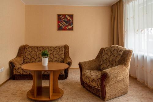 a living room with two chairs and a table at Šiaurės Vartai in Joniškis