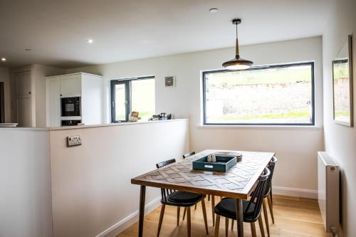 a kitchen and dining room with a table and chairs at 2 Bed Ground Floor Apartment - 3 Plas in Pistyll