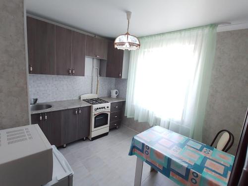 a kitchen with a sink and a stove top oven at Апартаменты 11 мкрн-8 in Aktobe