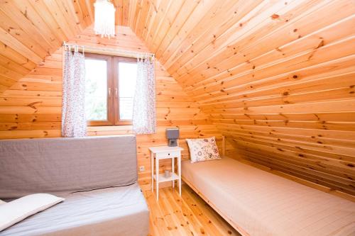 a log cabin with two beds and a window at domki letniskowe Ustka Sosnowo in Ustka