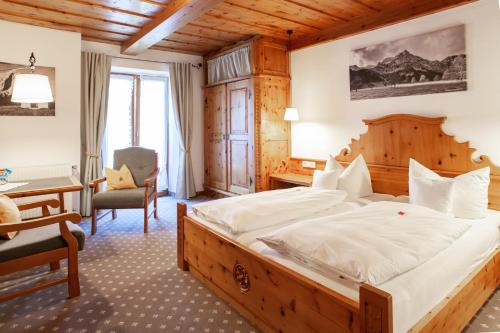 a bedroom with a large bed and a desk at Gästehaus Sonnenheim in Mittenwald