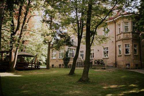 a large house with trees in front of it at Hotel Dębowy Biowellness & SPA Góry Sowie in Bielawa