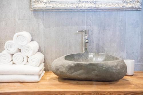 a bathroom with a large rock sink and towels at Alpegg Chalets in Waidring