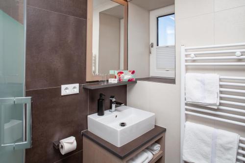 a bathroom with a sink and a mirror at Gästehaus Sonnenheim in Mittenwald