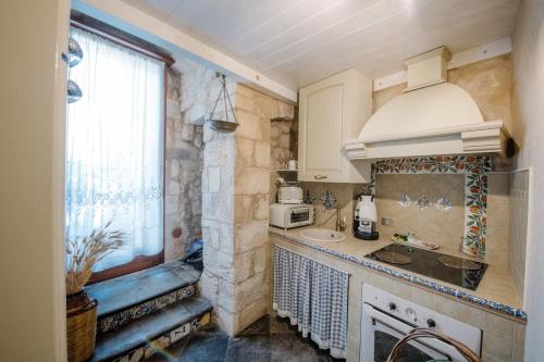 a small kitchen with a sink and a microwave at Le Cacinare in Modica