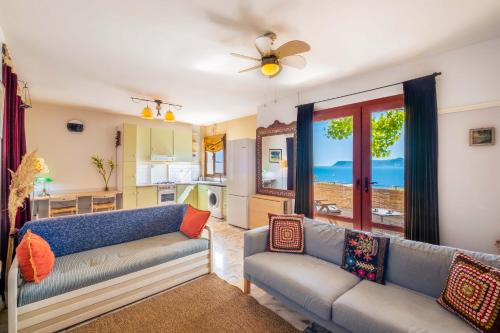 a living room with two couches and a kitchen at Barış Apartment with Seaview in Kaş