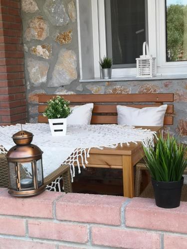 a bed on a porch with a table and a window at Makis Nest Apart-Hotel in Vourvourou