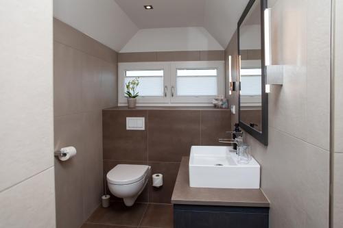 a bathroom with a white toilet and a sink at Gästehaus Sonnenheim in Mittenwald