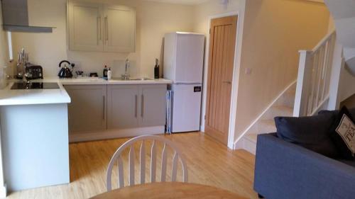 a kitchen with a white refrigerator and a table at Newditch Farm Accommodation in Bristol