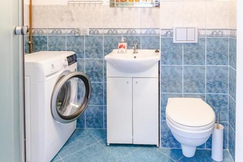 a bathroom with a washer and a toilet and a sink at AL-DOM Apartamenty Apartament IZI in Kołobrzeg