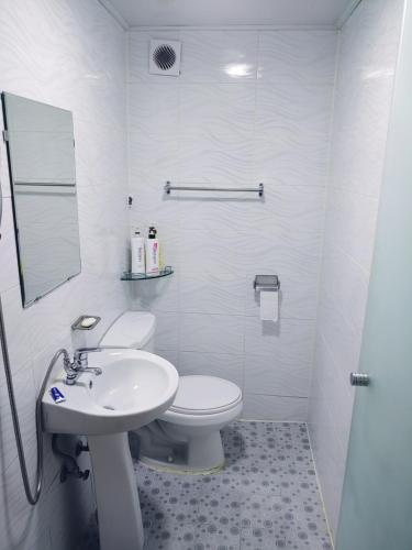 a white bathroom with a toilet and a sink at Able Guesthouse Hongdae 2 in Seoul