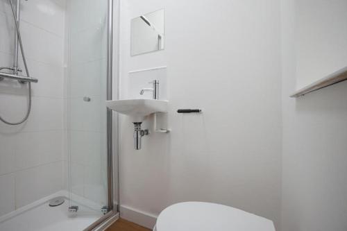 a white toilet sitting next to a white sink at Granite House Apartments in Liverpool