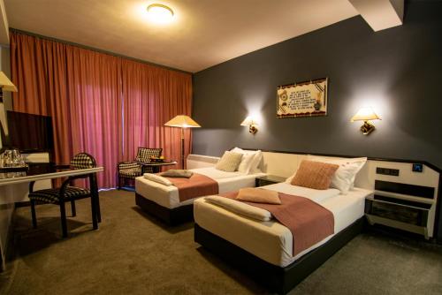 a hotel room with two beds and a desk at La Conacul Vesel Săpânța in Săpînţa