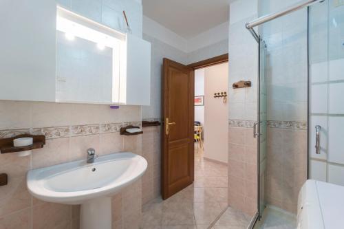 アルゲーロにあるMilka Apartmentの洗面台とガラスのシャワーを備えたバスルーム