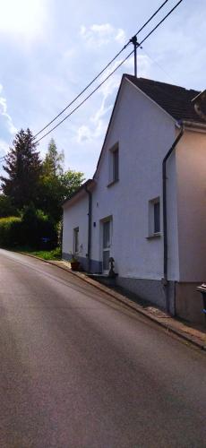 a white building on the side of a street at Casa Servatius in Briedel