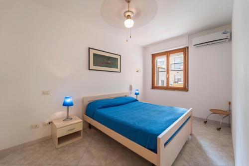 アルゲーロにあるMilka Apartmentの青いベッドと窓のある寝室