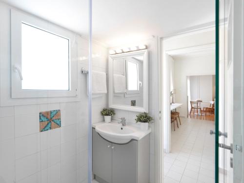 a white bathroom with a sink and a mirror at Modern Penthouse overlooking Halkis in Chalkida