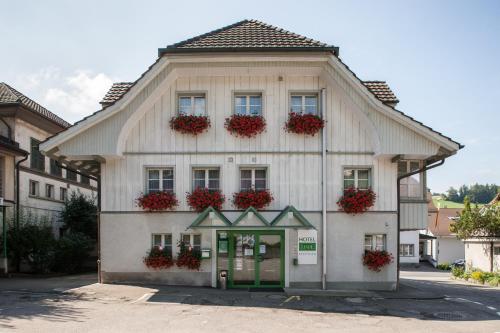 a building with flower boxes on the front of it at Seminarhotel Linde Stettlen in Bern