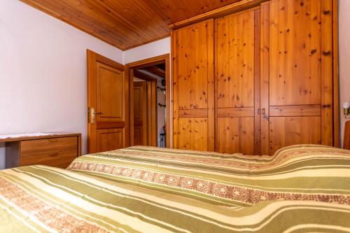 a bedroom with a bed and wooden cabinets at Casa Morel in Falcade