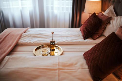 a tray with a drink and a candle on a bed at Hotel Dębowy Biowellness & SPA Góry Sowie in Bielawa