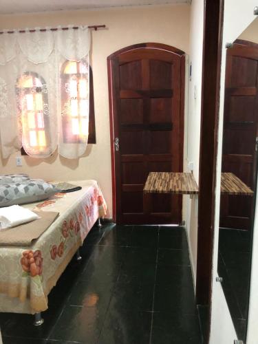 a bedroom with a bed and a door and a window at Flat Maricá II in Maricá