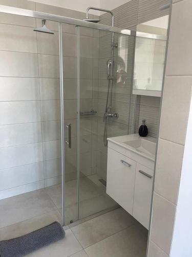 a bathroom with a glass shower with a sink at Villa Aspria in Rethymno