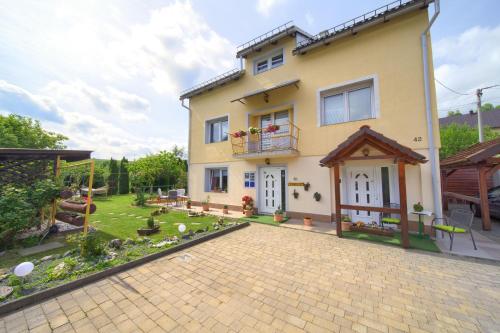 a house with a patio and a yard at Apartmani Sabina in Fužine