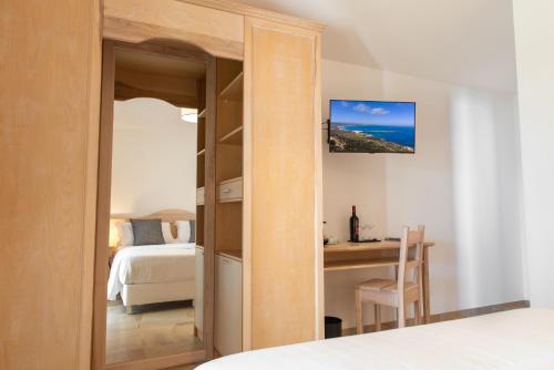 a bedroom with a bed and a desk with a table at MARISTESI in Siniscola