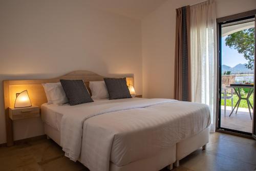 a bedroom with a large bed and a balcony at MARISTESI in Siniscola