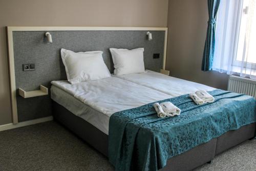 ein Schlafzimmer mit einem Bett mit Handtüchern darauf in der Unterkunft Hotel Laguna Terrace in Kawarna